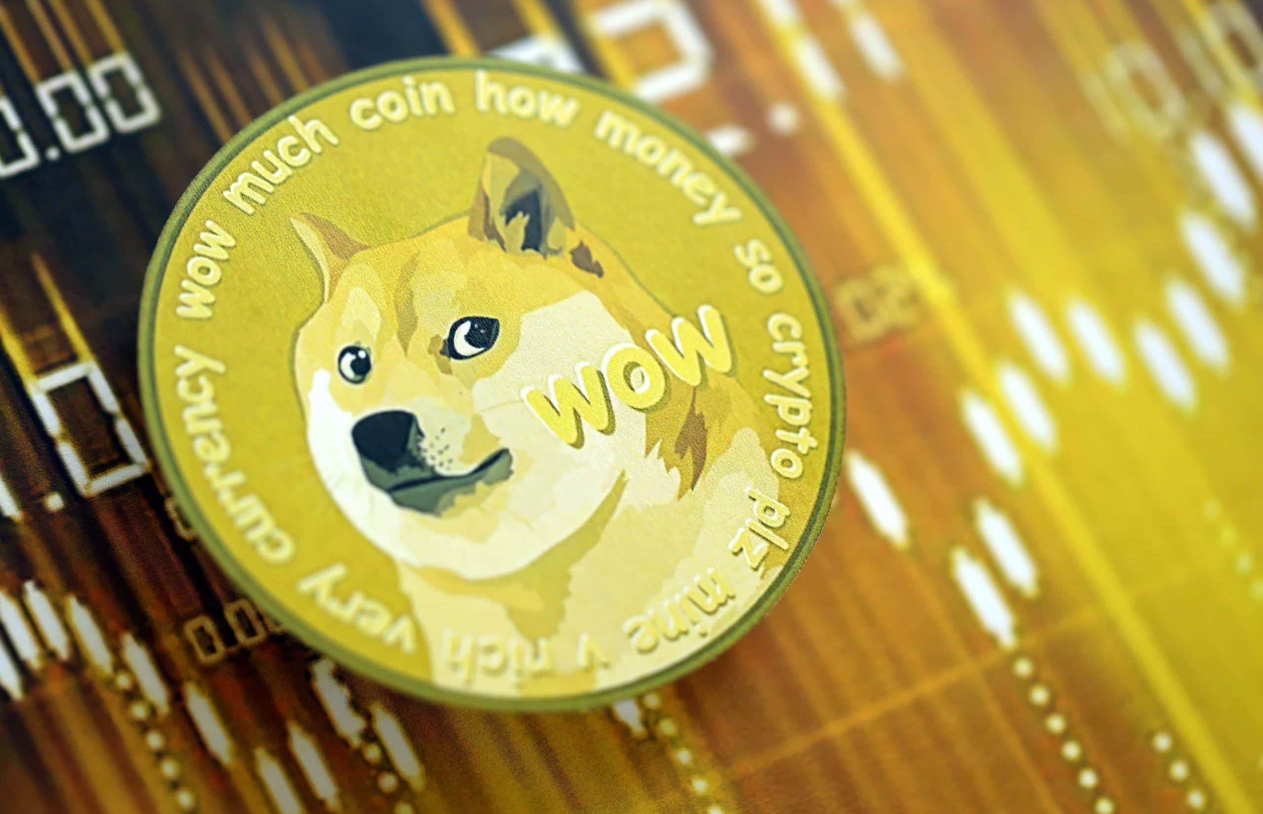 Eine physische Dogecoin-Münze mit dem kultigen Logo und den Meme-Sprüchen sitzt auf einem unscharfen Kryptowährungspreisdiagramm in Gelb- und Brauntönen.